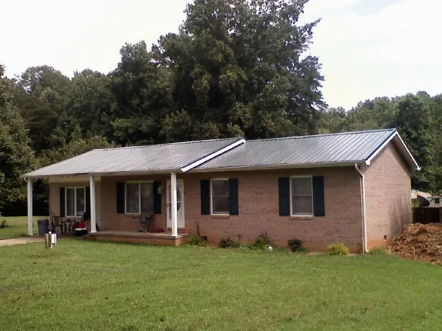 Gray metal roof on a brick ranch house with a side carport in Brian Head