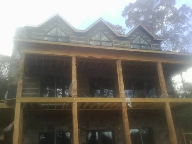 Dormers and porch framing on a large log home under construction — Roof Coating work by our crew in Brian Head