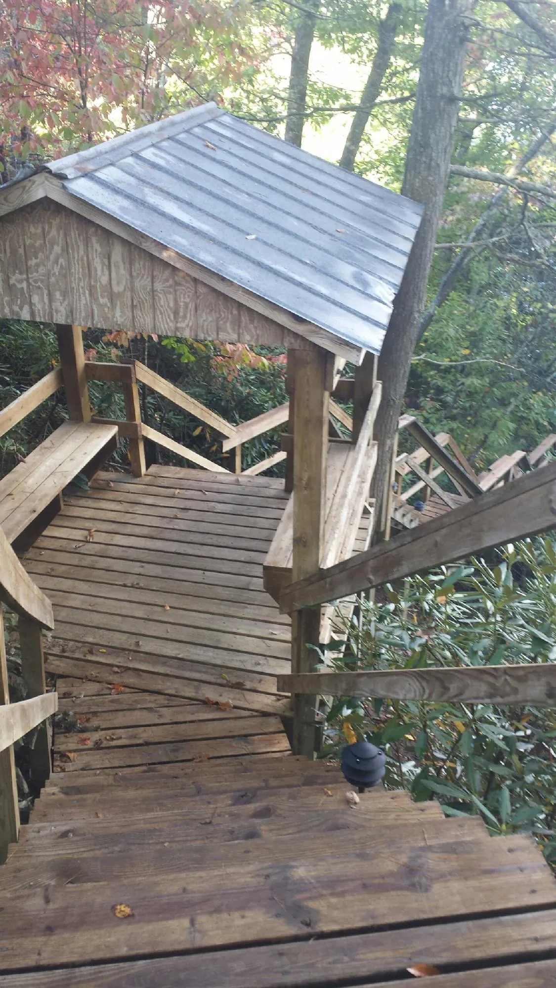 Metal roofed shelter over wooden steps on a wooded walkway — Skylight Repair & Installation work by our crew in Brian Head